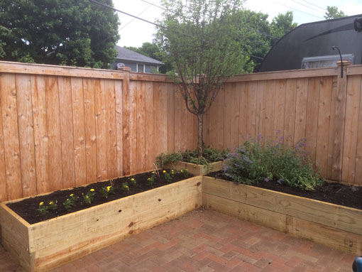 Raised vegetable gardens made of cedar slats vertically attached to posts. 