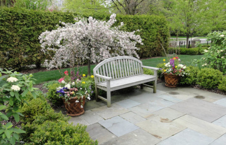 Bluestone patio with blooming crabapple and spring planters