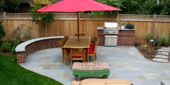 bluestone patio with mortared brick seatwall and built-in grill - Nature's Perspective Landscaping