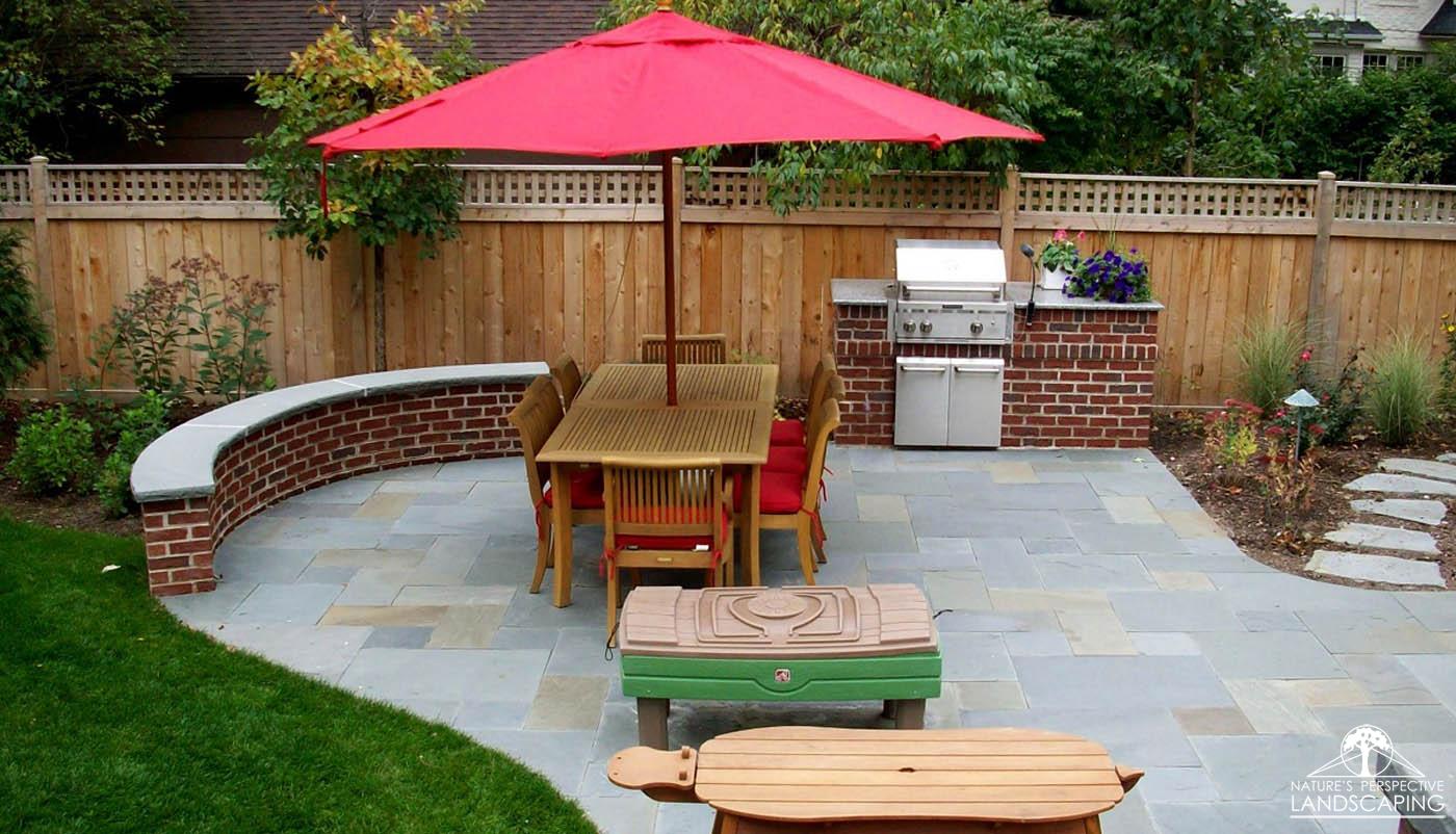 bluestone patio with mortared brick seatwall and built-in grill - Nature's Perspective Landscaping
