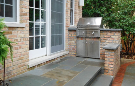 Built-in grill with brick wall to match house and bluestone steps and stoop