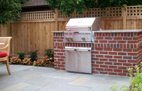 mortared brick built-in grill with bluestone patio