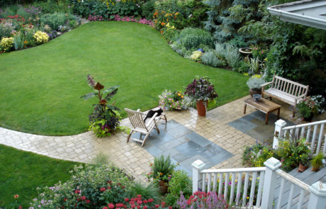 Entire backyard with paver and bluestone patio, large lawn, and flowering perennials