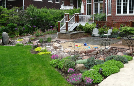 Kid-friendly garden with low plantings, sand pit, and bluestone patio