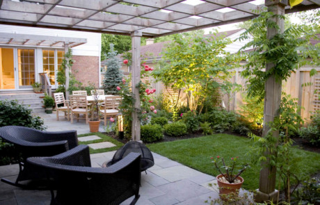 Quaint backyard utilizes its full potential with pergolas, patios, lighting, and lattices
