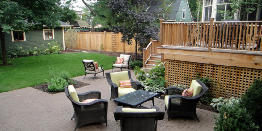 backyard with high deck and clay paver patio-Nature's Perspective Landscaping