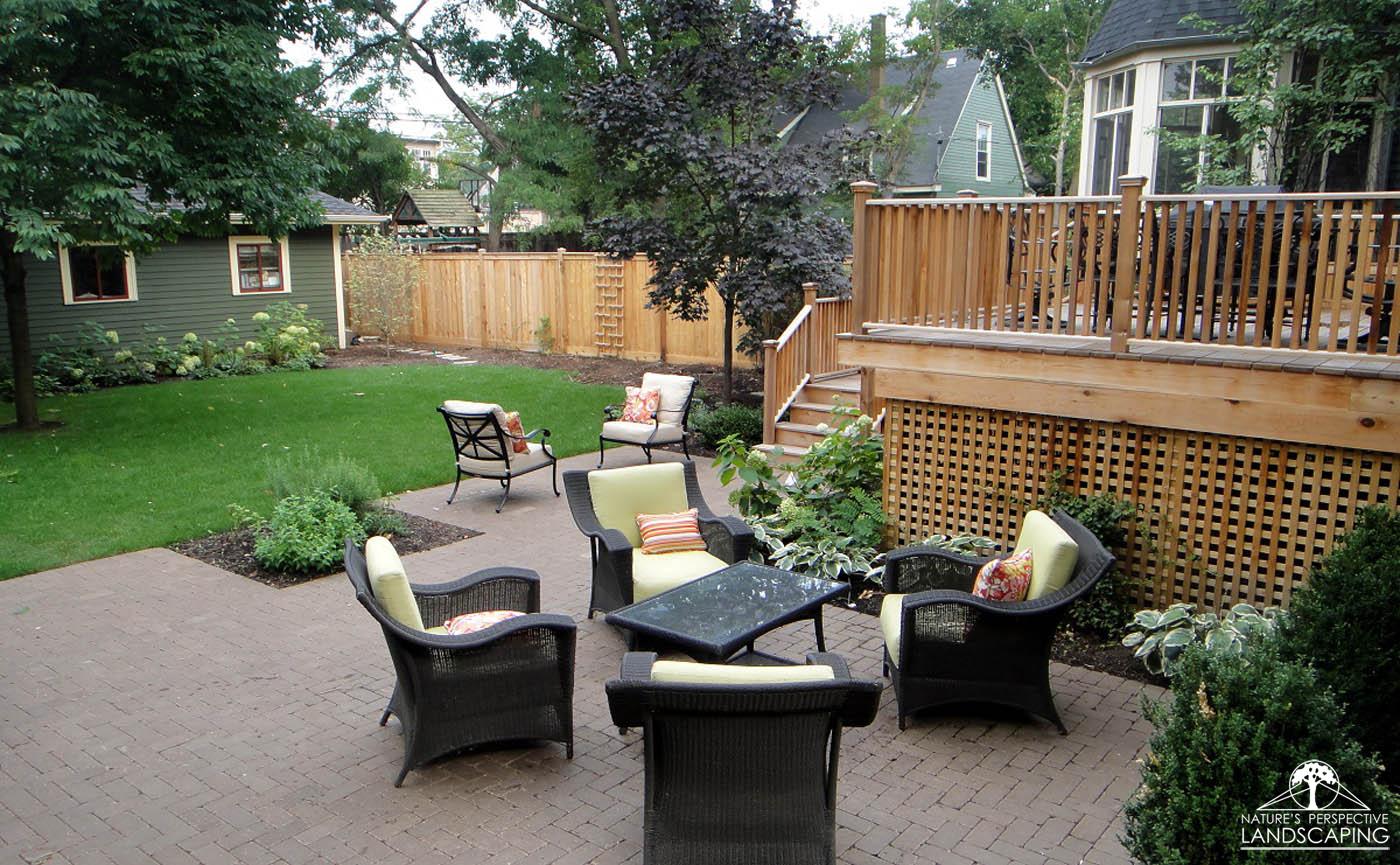 backyard with high deck and clay paver patio-Nature's Perspective Landscaping