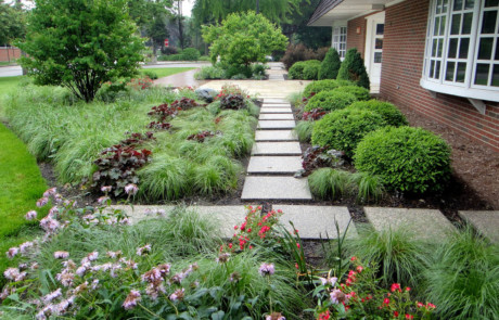 Business entry landscape with travertine slabs and colorful perennials