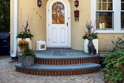 curved front door with curved bluestone and brick stoop and steps