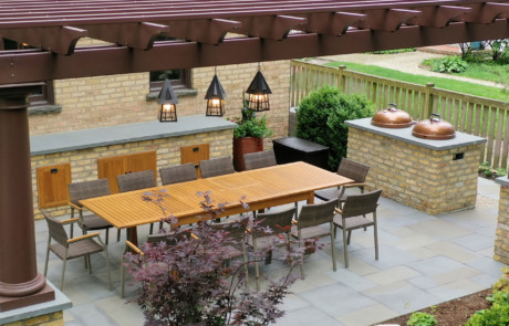 fiberglass pergola over outdoor kitchen and dining table with double Weber grills