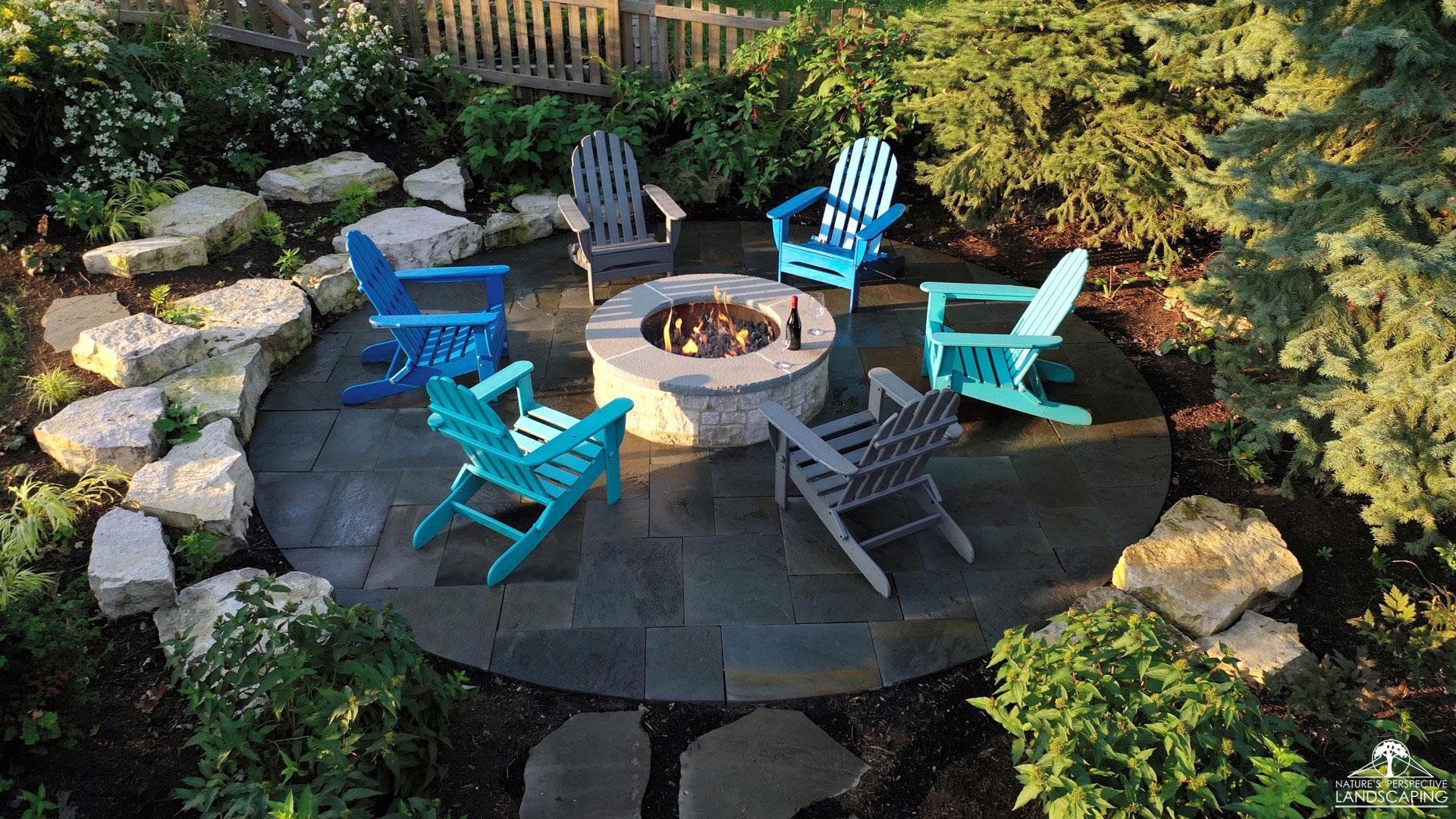 a round bluestone fire pit area with outcropping boulders