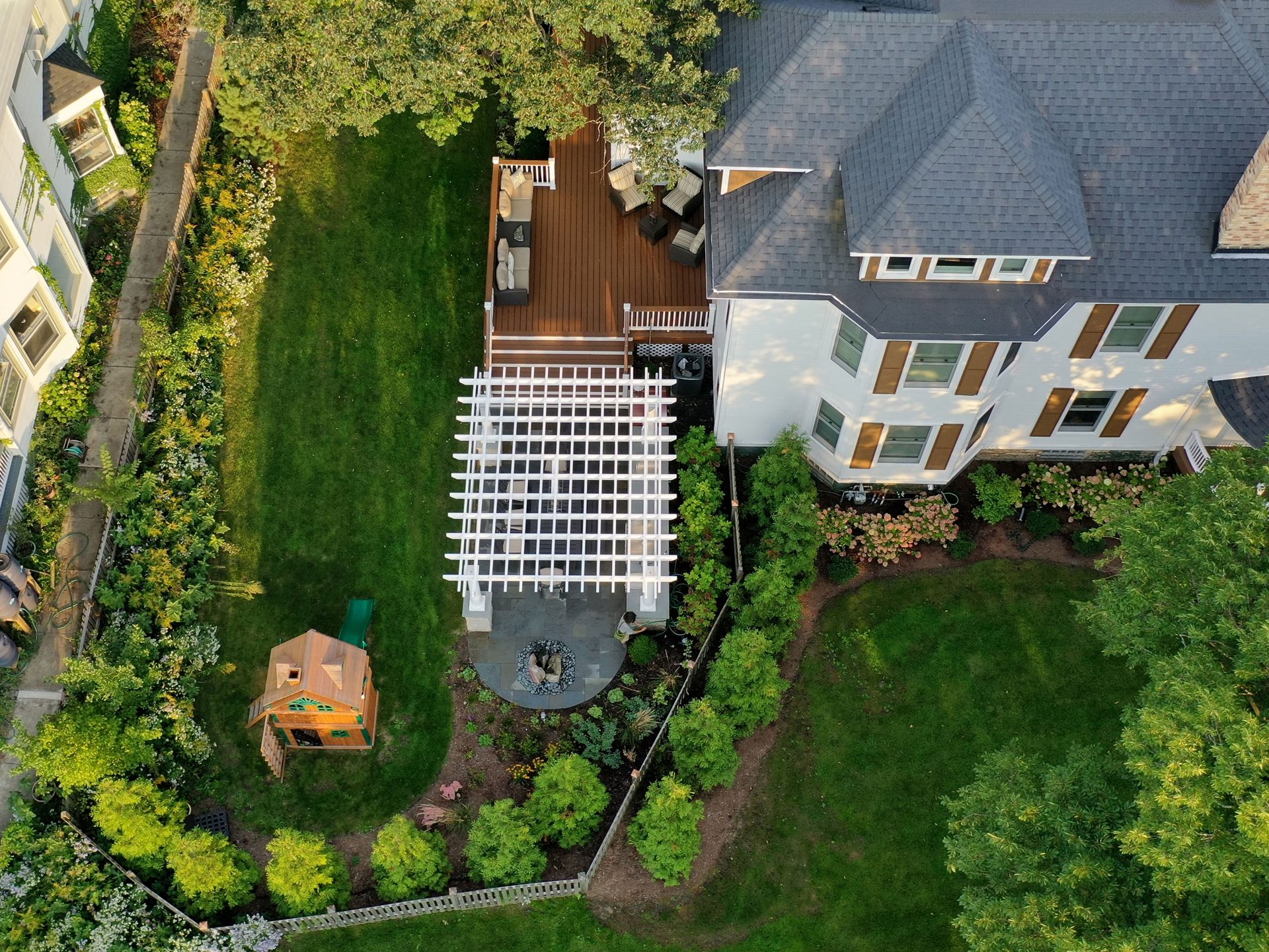 spacious backyard with lawn, pergola, outdoor kitchen, dining area and deck