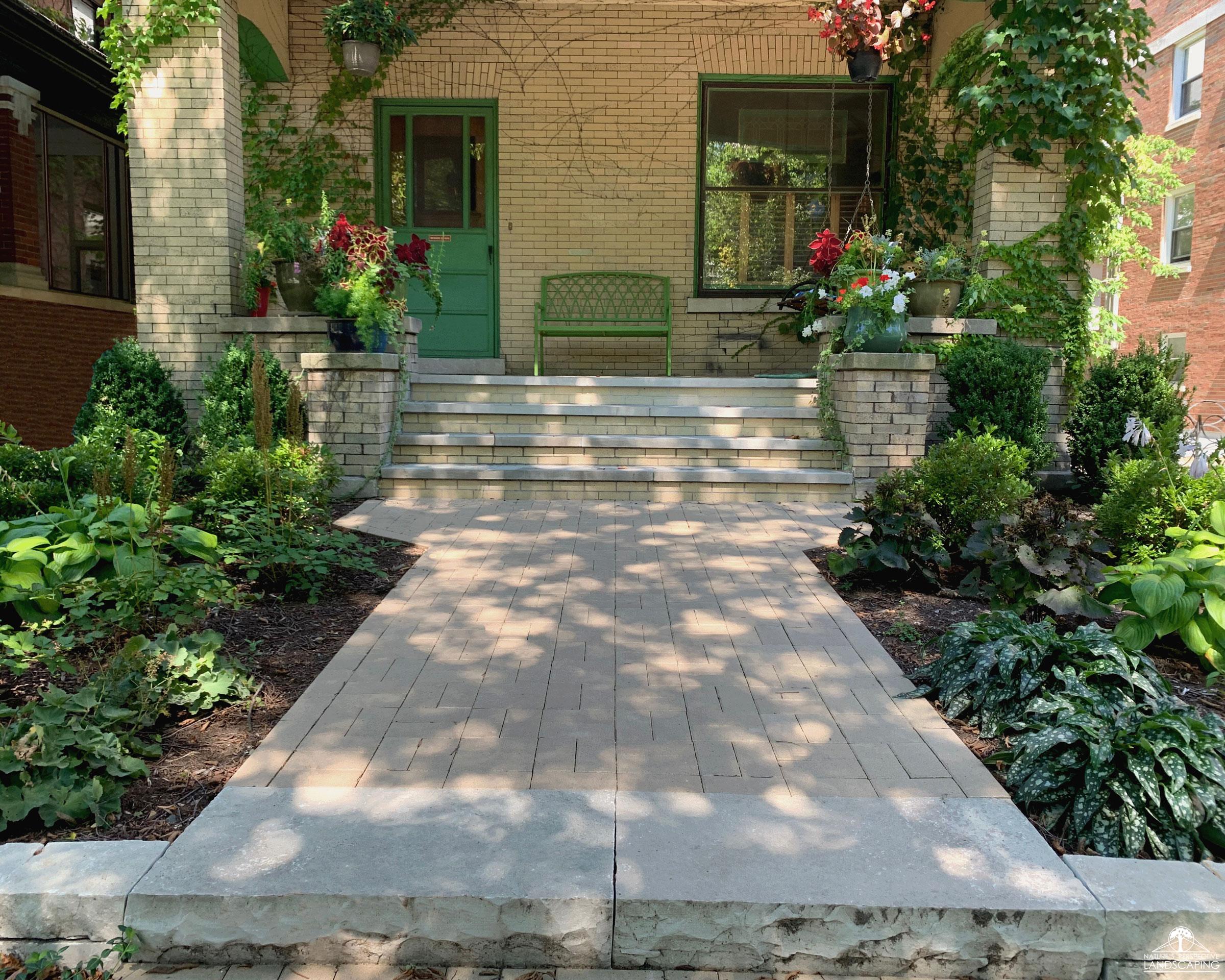 front entrance with wide clay paver walk, limestone step and brick-clad stoop