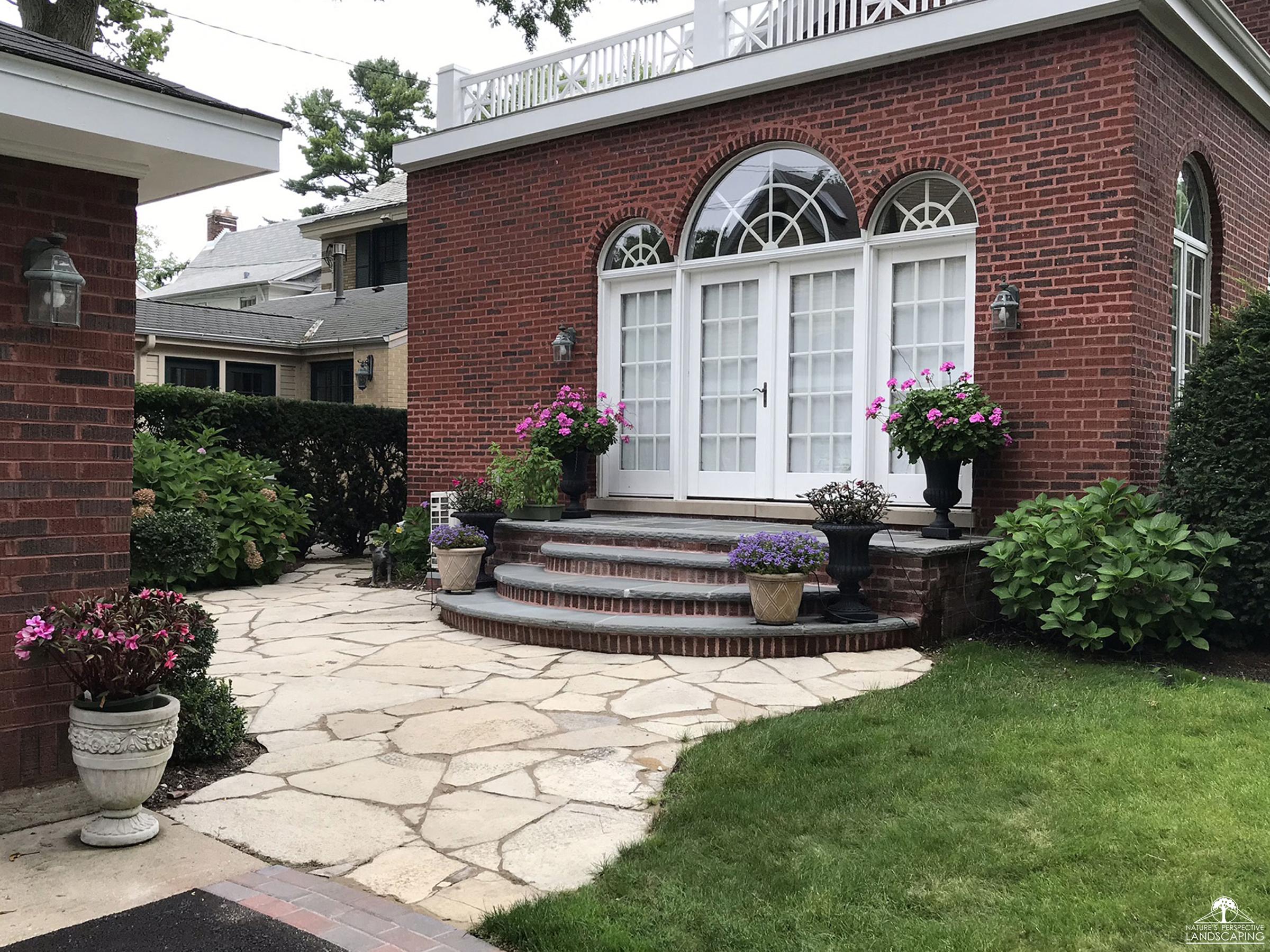 French doors with bluestone and brick stoop, steps and limestone patio