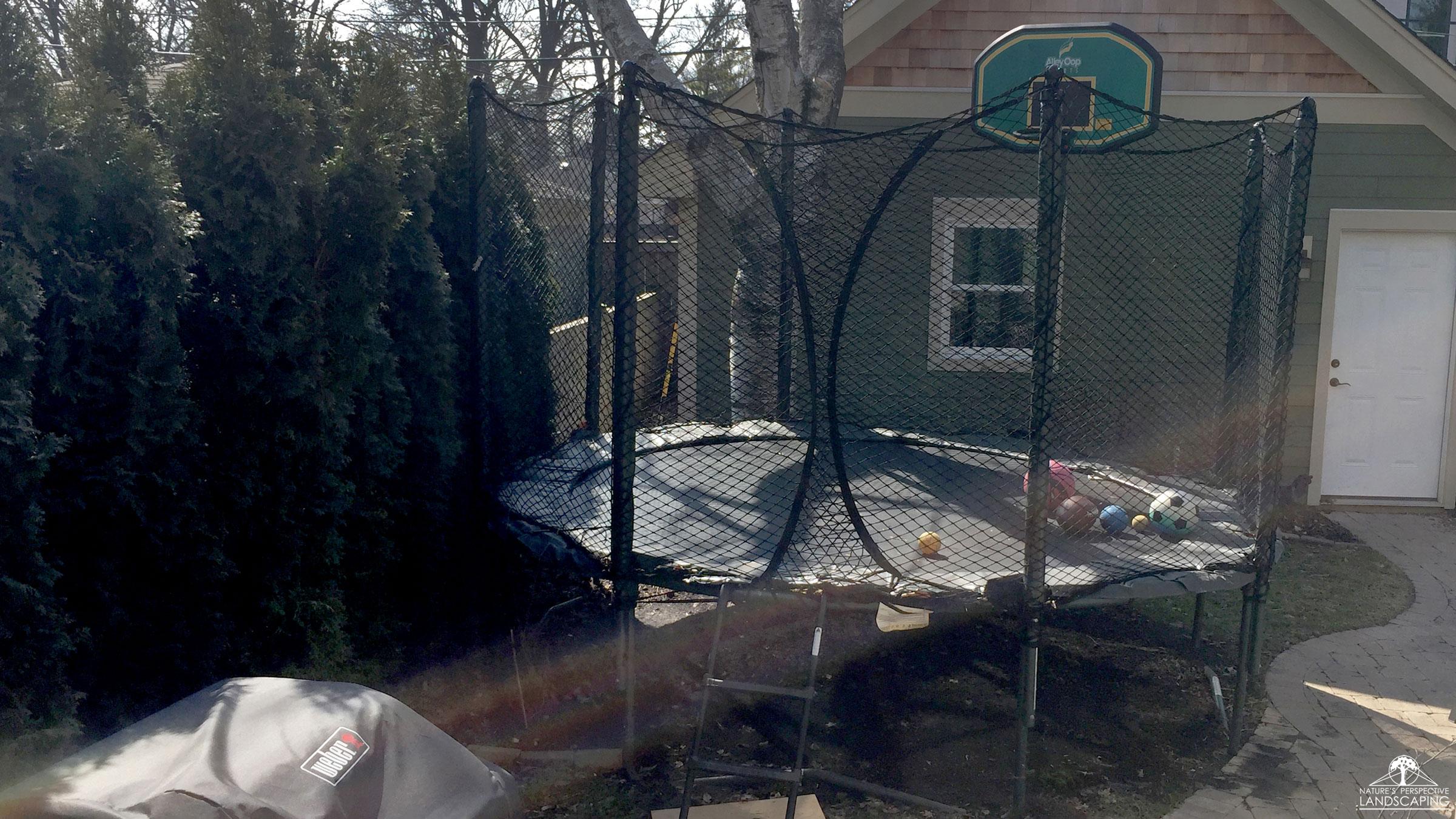 small backyard before photo with trampoline