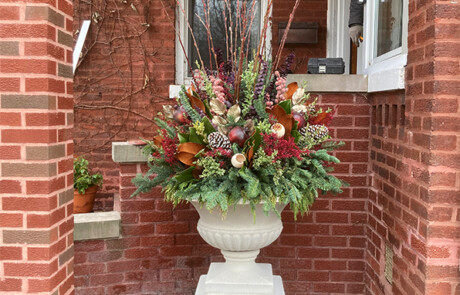 Winter Container - A mix of evergreen, branches, and red/pink accents